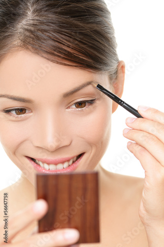 Photo: Makeup girl putting eyebrow color in mirror Makeup girl putting eyebrow color in mirror
