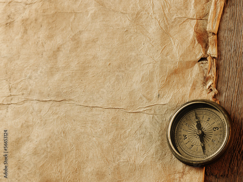 Photo: old compass on vintage background old compass on vintage background