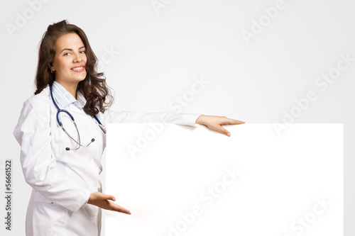 Photo: young woman doctor with a blank banner young woman doctor with a blank banner