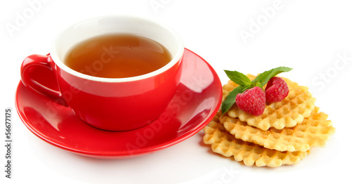 Photo: Cup of tea with cookies and raspberries isolated on white Cup of tea with cookies and raspberries isolated on white