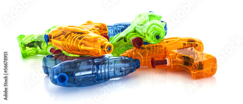 Photo: Pile of colorful plastic water pistols on a white background Pile of colorful plastic water pistols on a white background