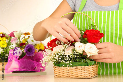 Photo: Florist makes flowers bouquet in wicker basket Florist makes flowers bouquet in wicker basket