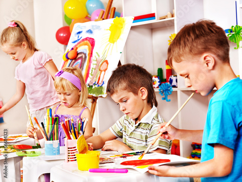 Photo: Children painting at easel. Children painting at easel.