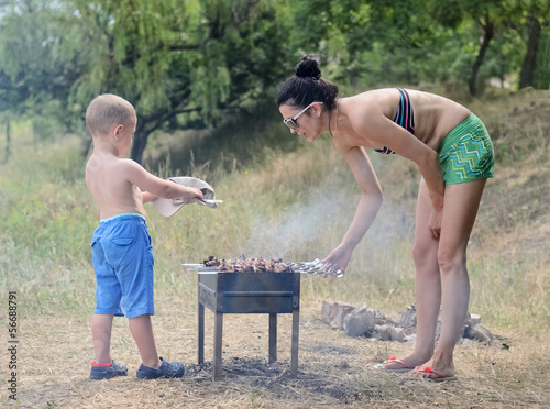 Photo: Young boy helping at the barbecue Young boy helping at the barbecue