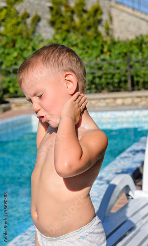 Photo: Young boy applying suntan lotion Young boy applying suntan lotion