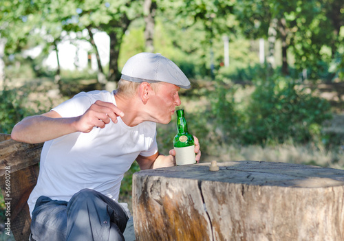 Photo: Man taking a swig of alcohol from a bottle Man taking a swig of alcohol from a bottle