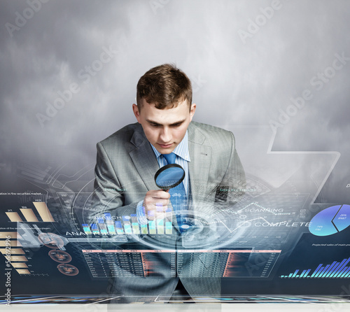 Photo: Man looking in magnifier Man looking in magnifier
