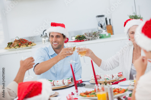 Photo: Happy family clinking their glasses of white wine Happy family clinking their glasses of white wine