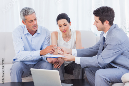 Photo: Salesman giving contract to client and his wife Salesman giving contract to client and his wife