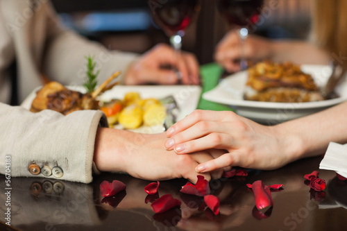 Photo: Close up on loving couple holding hands Close up on loving couple holding hands