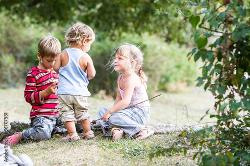 Photo: three happy children enjoying their time outdoors three happy children enjoying their time outdoors