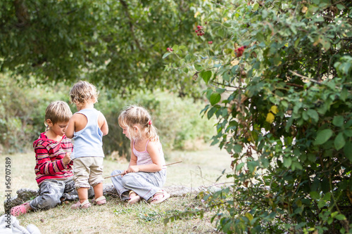 Photo: three happy children enjoying their time outdoors three happy children enjoying their time outdoors