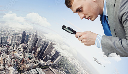 Photo: Man looking in magnifier Man looking in magnifier