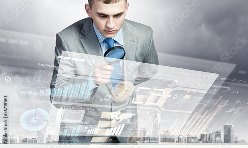 Photo: Man looking in magnifier Man looking in magnifier