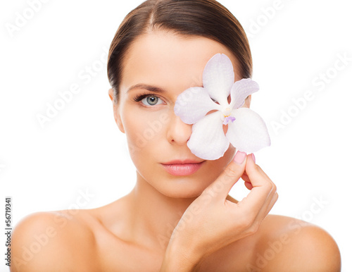 Photo: relaxed woman with orсhid flower over eye relaxed woman with orсhid flower over eye