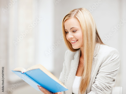 Photo: young woman reading book at school young woman reading book at school