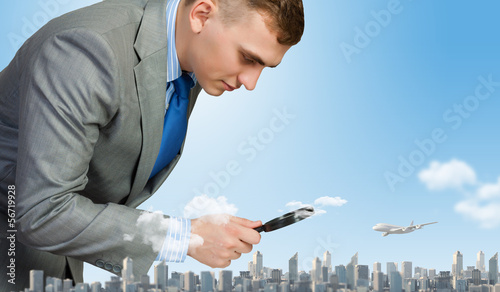 Photo: Man looking in magnifier Man looking in magnifier
