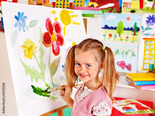 Photo: Child painting at easel. Child painting at easel.