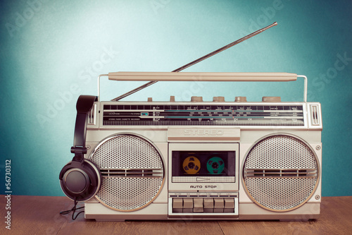 Photo: Retro cassette ghetto blaster and phones on table Retro cassette ghetto blaster and phones on table