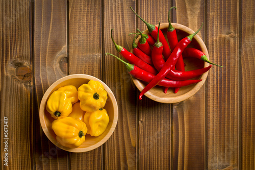 Photo: red chili peppers and habanero on wooden table red chili peppers and habanero on wooden table