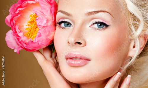 Photo: beautiful blonde girl with pink flower. perfect skin. beautiful blonde girl with pink flower. perfect skin.