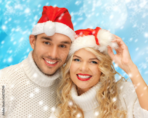 Photo: family couple in sweaters and santa's hats family couple in sweaters and santa's hats