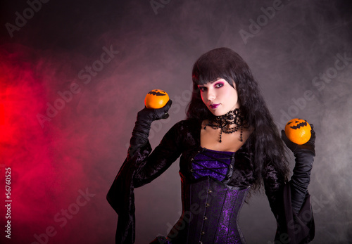 Photo: Portrait of attractive witch in purple gothic Halloween costume Portrait of attractive witch in purple gothic Halloween costume