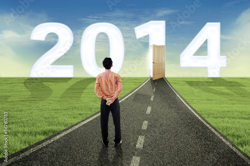 Photo: Young businessman looking into the future in 2014 Young businessman looking into the future in 2014