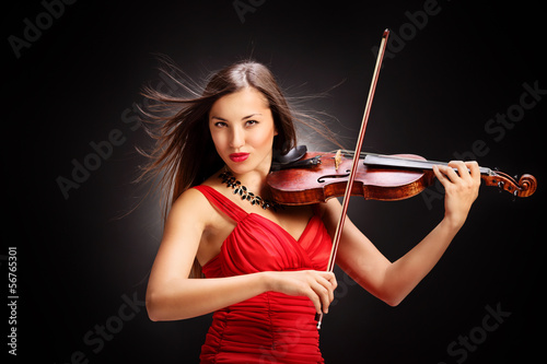 Photo: Young woman in red dress playing the violin Young woman in red dress playing the violin