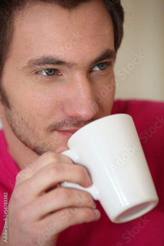 Photo: Man drinking from a mug Man drinking from a mug