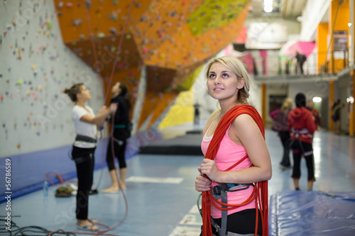 Photo: The girl with rope on shoulder on the climbing gym The girl with rope on shoulder on the climbing gym