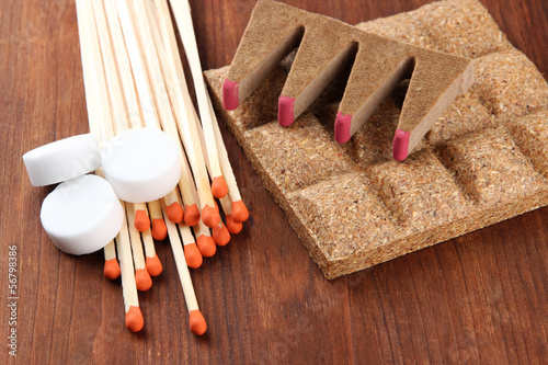 Photo: Long matches and dry fuel, on wooden background Long matches and dry fuel, on wooden background