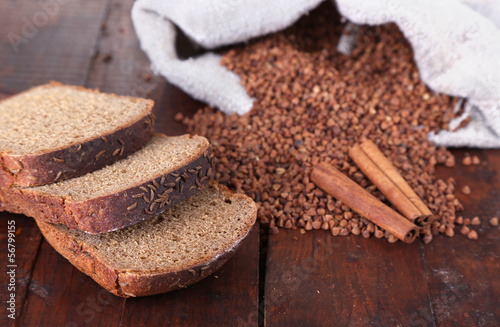 Photo: Cloth bag with buckwheat and bread on wooden background Cloth bag with buckwheat and bread on wooden background