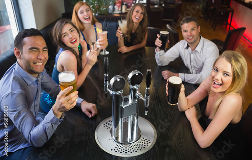 Photo: Laughing friends raising their glasses up Laughing friends raising their glasses up