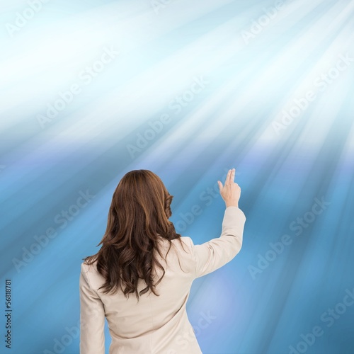 Photo: Brunette businesswoman standing back to camera pointing at somet Brunette businesswoman standing back to camera pointing at somet