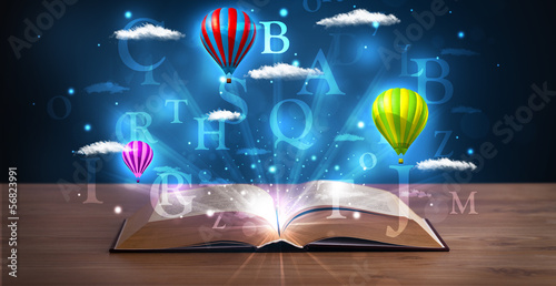 Photo: Open book with glowing fantasy abstract clouds and balloons Open book with glowing fantasy abstract clouds and balloons