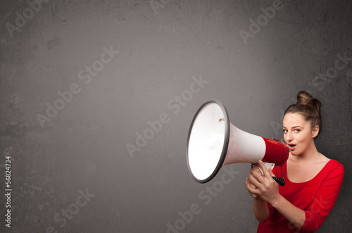 Photo: Girl shouting into megaphone on copy space background Girl shouting into megaphone on copy space background