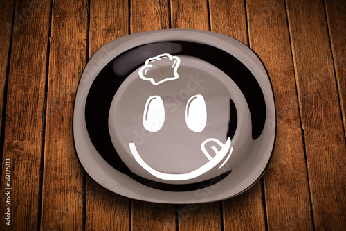 Photo: Happy smiley cartoon face on colorful dish plate Happy smiley cartoon face on colorful dish plate