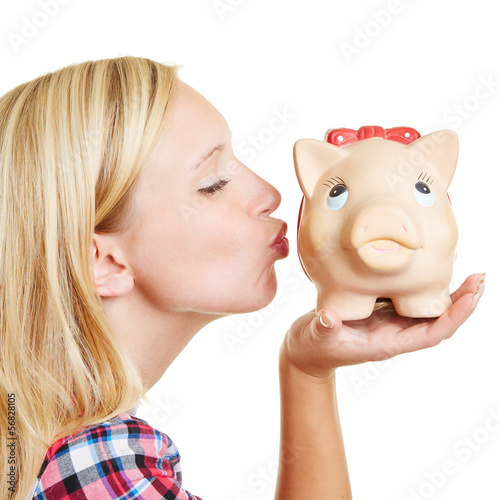 Photo: Blond woman kissing piggy bank Blond woman kissing piggy bank