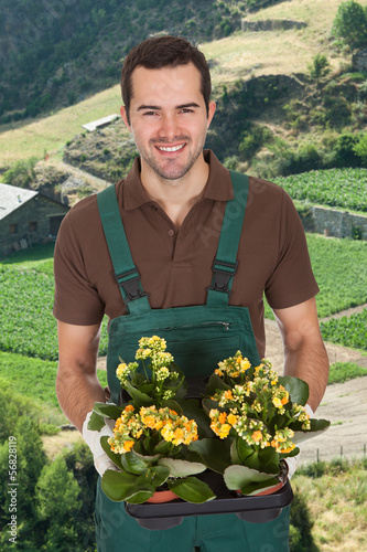 Photo: Young Man Holding Flower Plant Young Man Holding Flower Plant