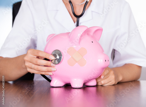 Photo: Doctor With Piggy Bank And Stethoscope Doctor With Piggy Bank And Stethoscope