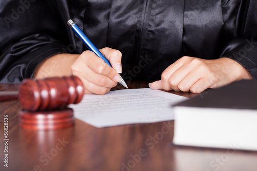 Photo: Female Judge Writing On Paper Female Judge Writing On Paper