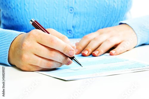 Photo: Business woman filling document. Business woman filling document.