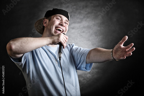 Photo: Rap singer man with microphone cool hand gesture Rap singer man with microphone cool hand gesture