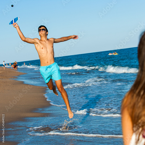 Photo: Young beach smash ball player in action. Young beach smash ball player in action.