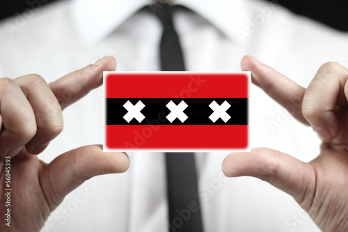 Photo: Businessman holding a business card with a Amsterdam City Flag Businessman holding a business card with a Amsterdam City Flag
