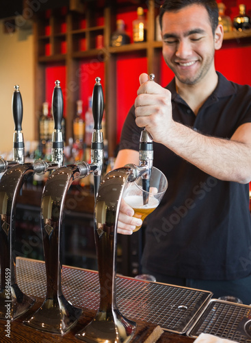 Photo: Handsome barkeeper pulling a pint of beer Handsome barkeeper pulling a pint of beer