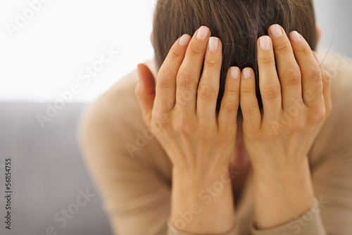 Photo: Stressed young woman sitting on couch Stressed young woman sitting on couch