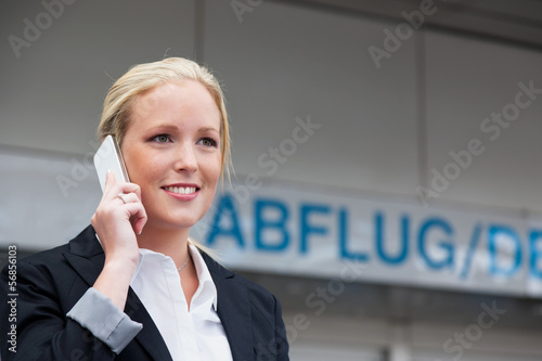Photo: Frau telefoniert mit Handy am Flughafen Frau telefoniert mit Handy am Flughafen