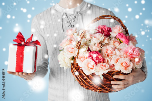 Photo: man holding basket full of flowers and gift box man holding basket full of flowers and gift box
